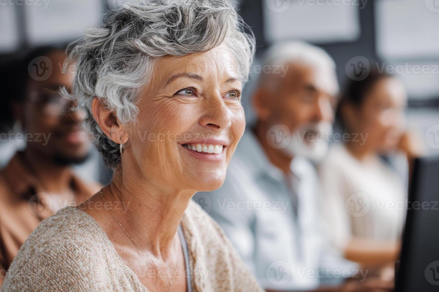 Joyful older woman engages in a workshop alongside a group of diverse learners. The setting is a contemporary classroom filled with natural light and learning resources photo