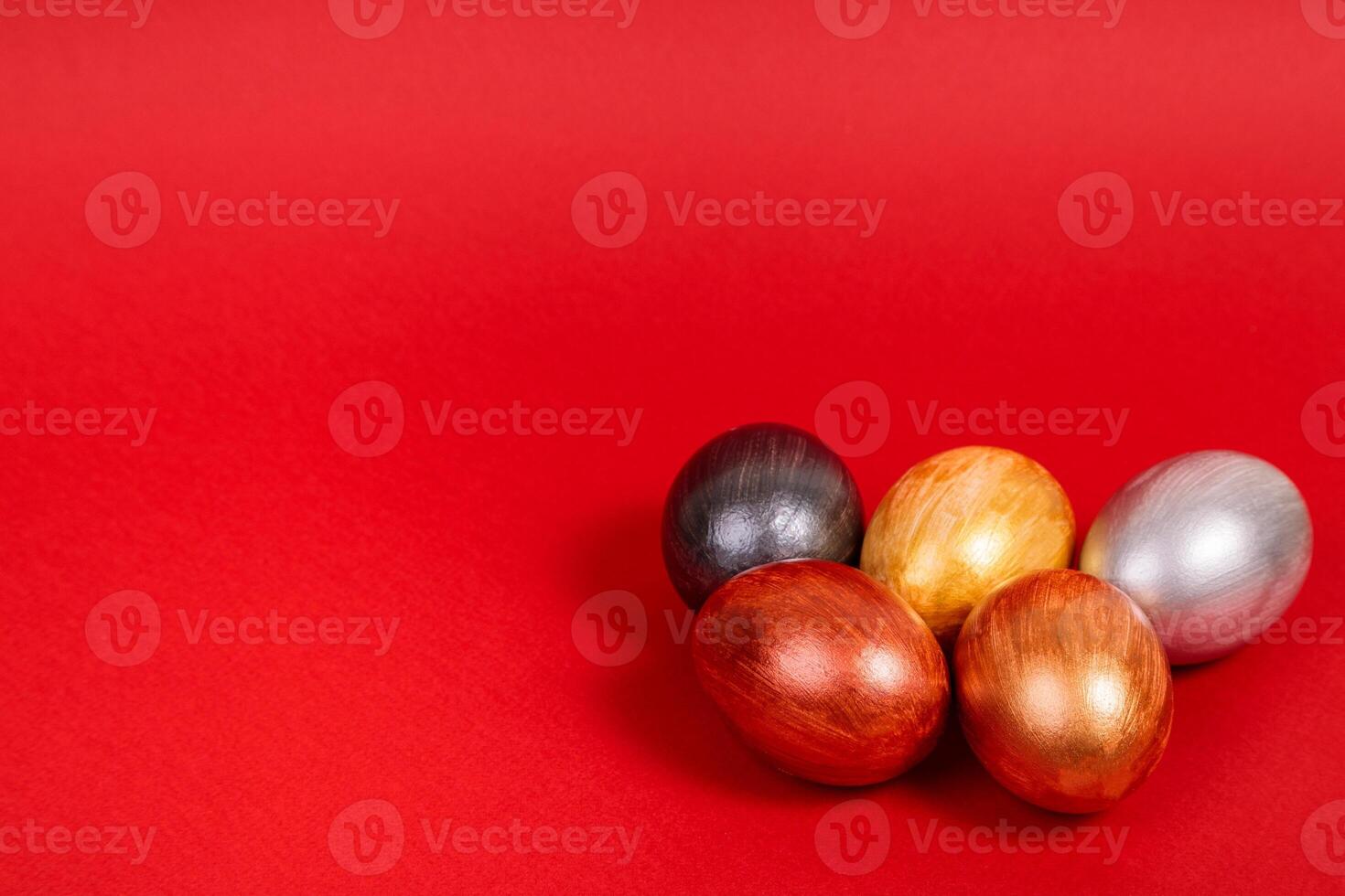 Multi-colored eggs on a uniform red background with place for text. photo