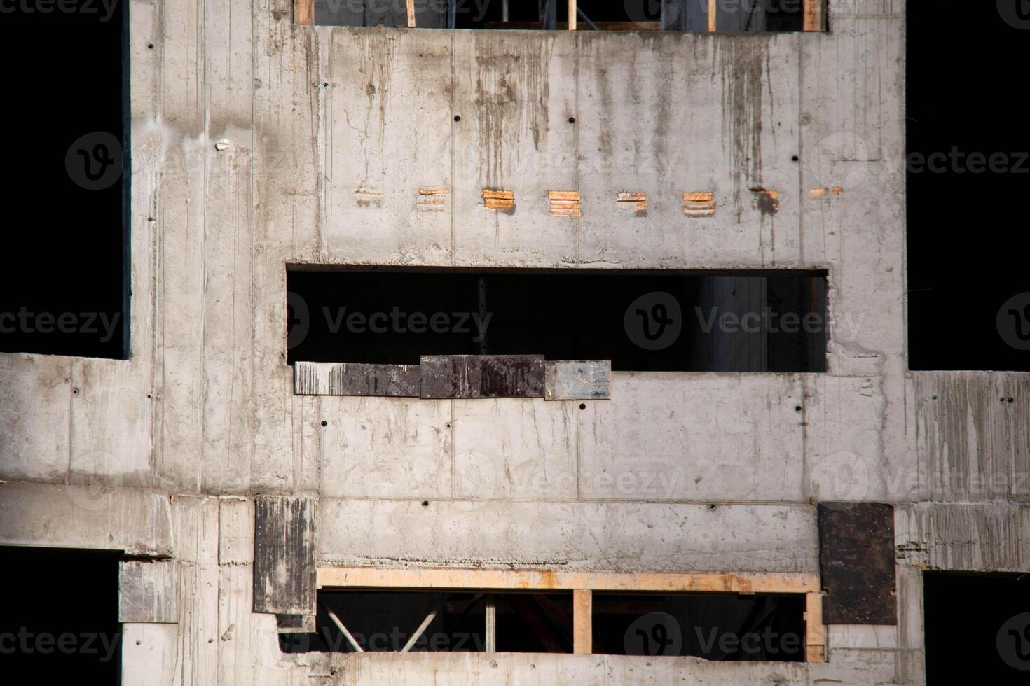 Concrete Frame of Building Under Construction. Architectural origin of Structure. Monolithic box with Wooden Lintels in Openings for Windows, Thermal Pads in Cement Wall at Construction Site Sunny Day photo