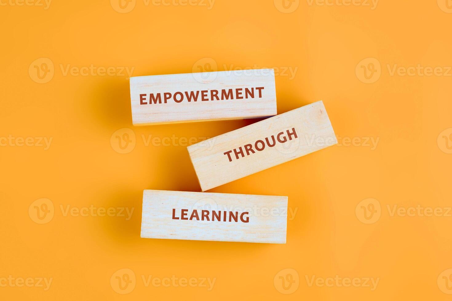 The message connect through learning. EMPOWERMENT THROUGH LEARNING assembled from blocks on orange background, top view photo