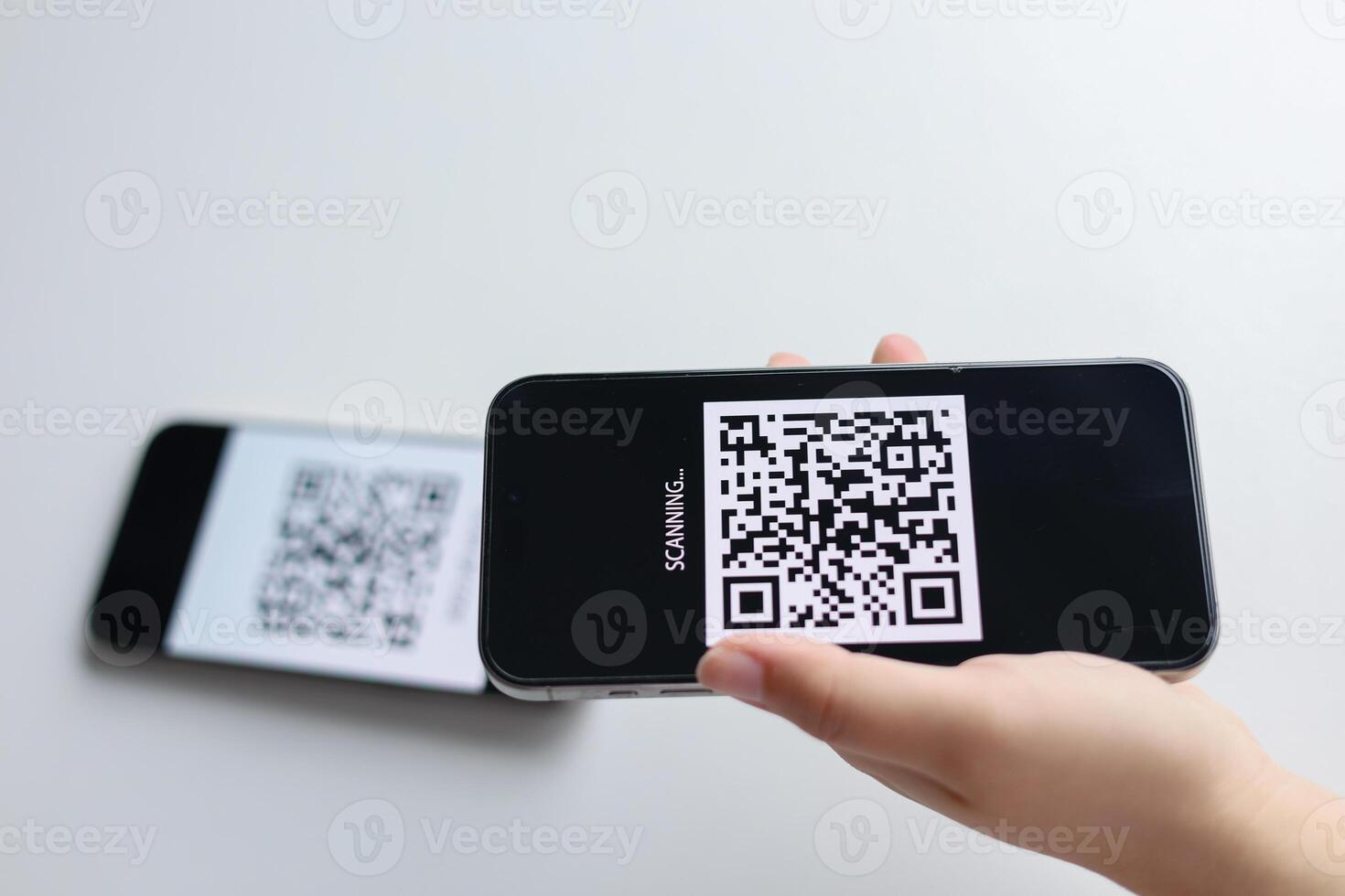 Close-up hands using a smartphone to scan a QR code. photo