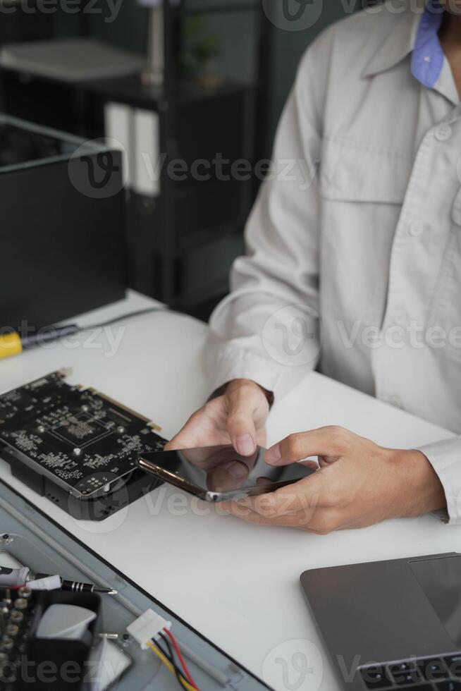 Computer Hardware dissemblers fixing computer PC, using phone. photo