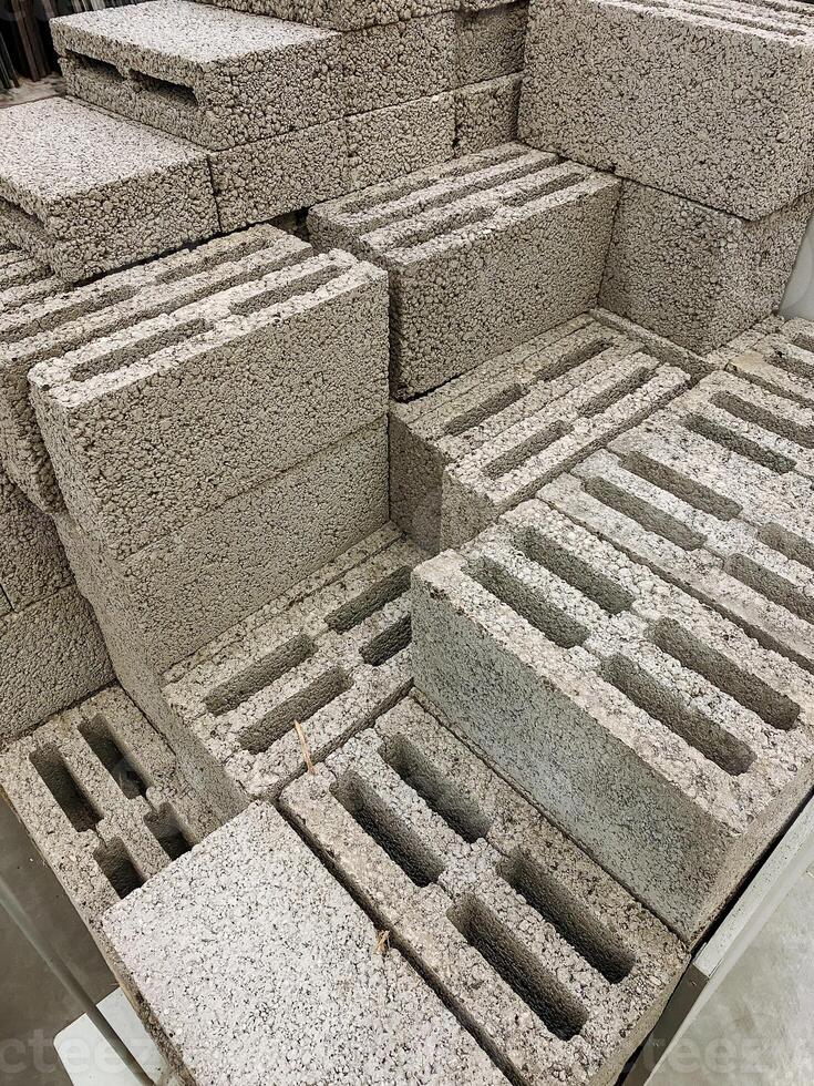 rough concrete textures, focusing on textured cinder blocks with visible aggregates and pores, intimate shot capturing rugged surface features of stacked concrete blocks with dust and hollow cores photo