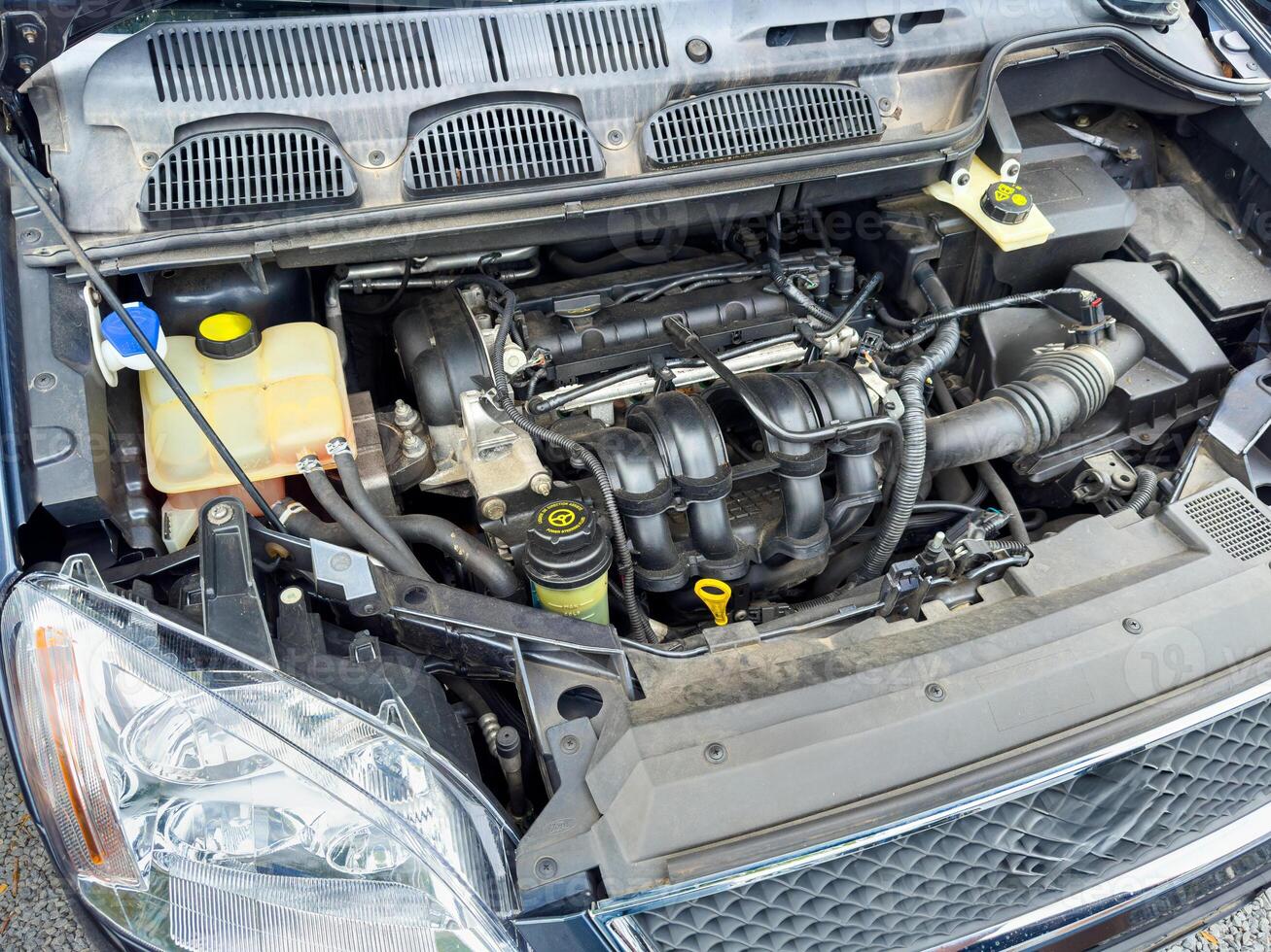 Exploring the intricate details of a car's engine compartment during a routine maintenance check in bright daylight photo