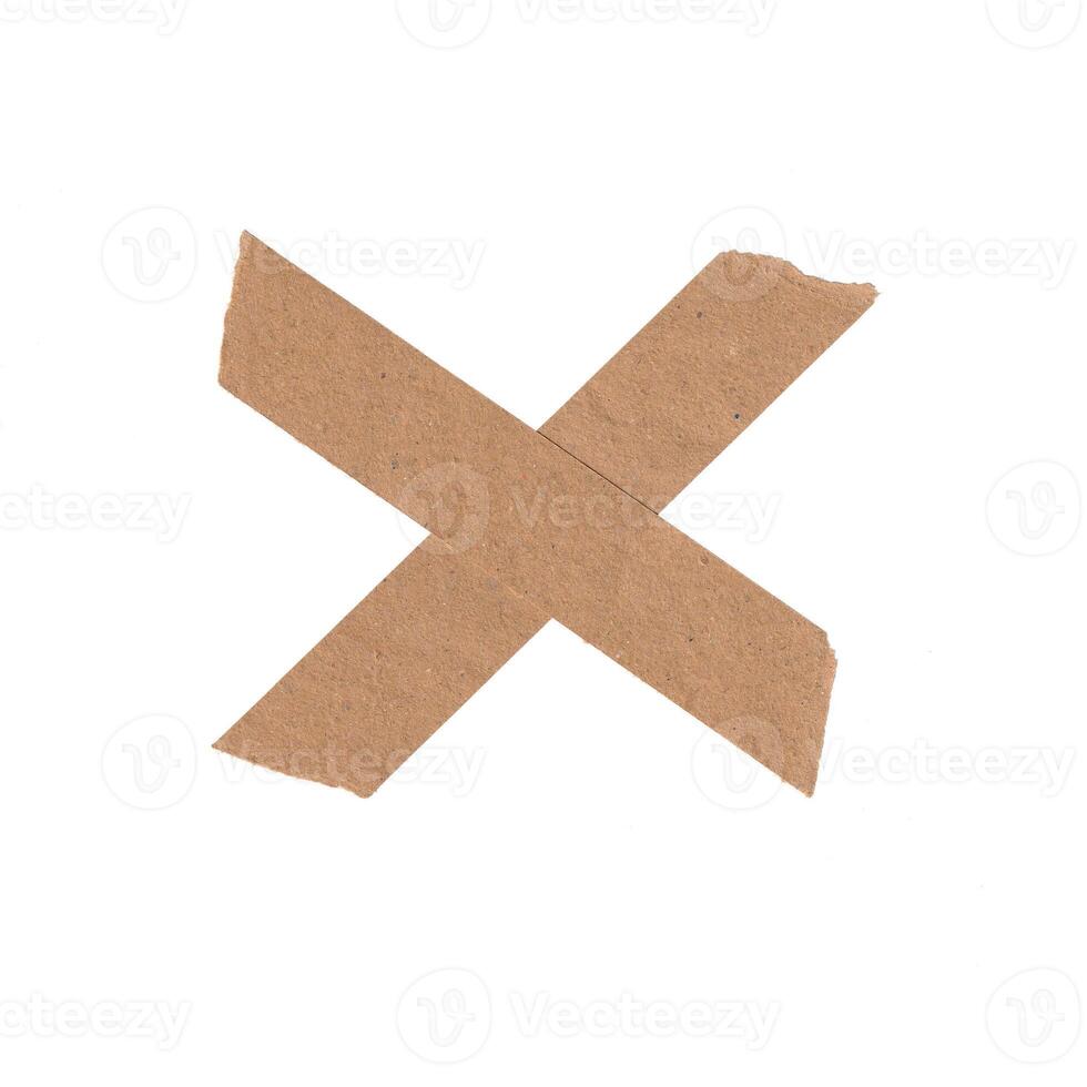 Realistic cross shape made of two strips of brown paper tape with torn, rough edges. Isolated rustic design element for marking or cancellation. photo