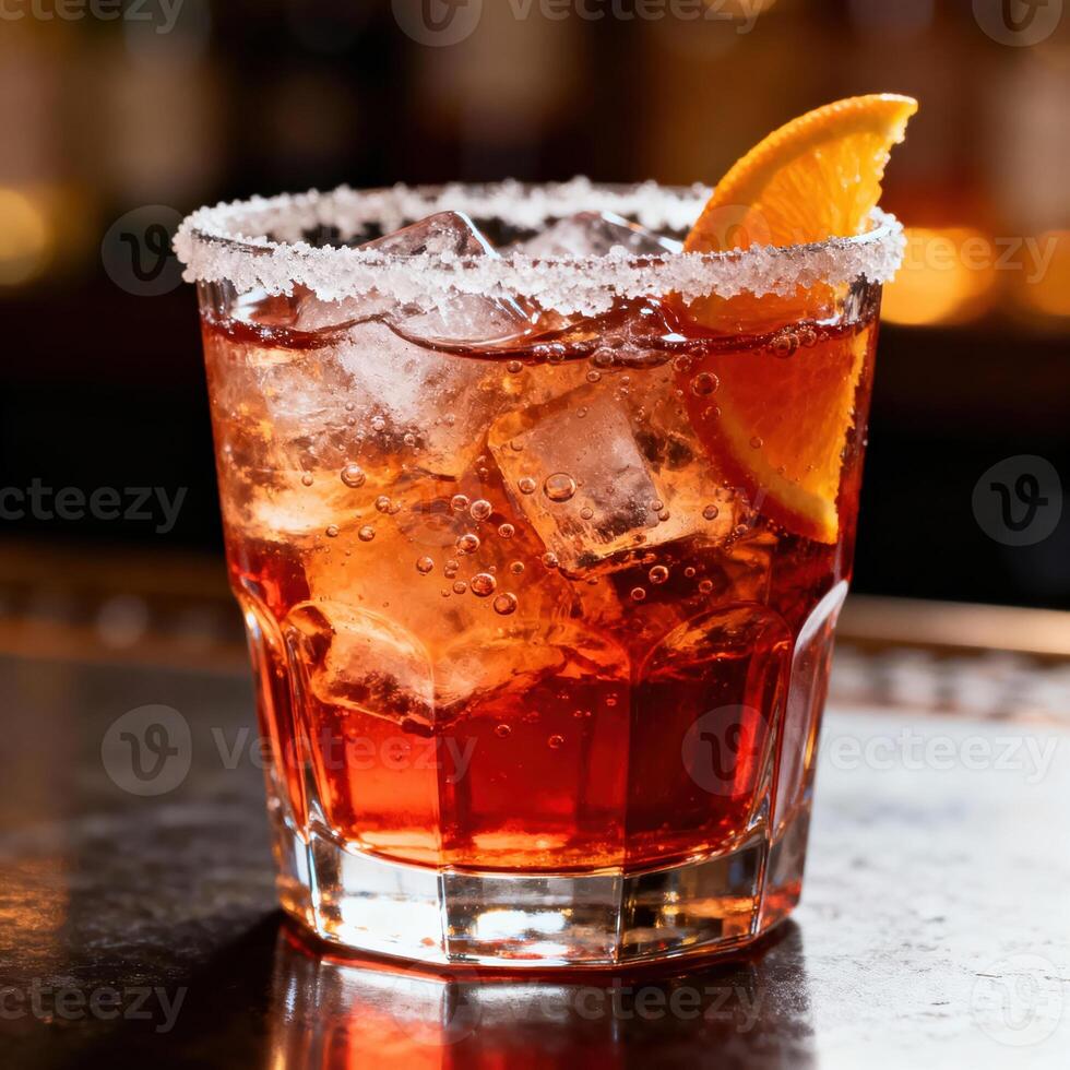 Refreshing ruby-colored beverage garnished with citrus and a sugar rim sits on a dark surface photo