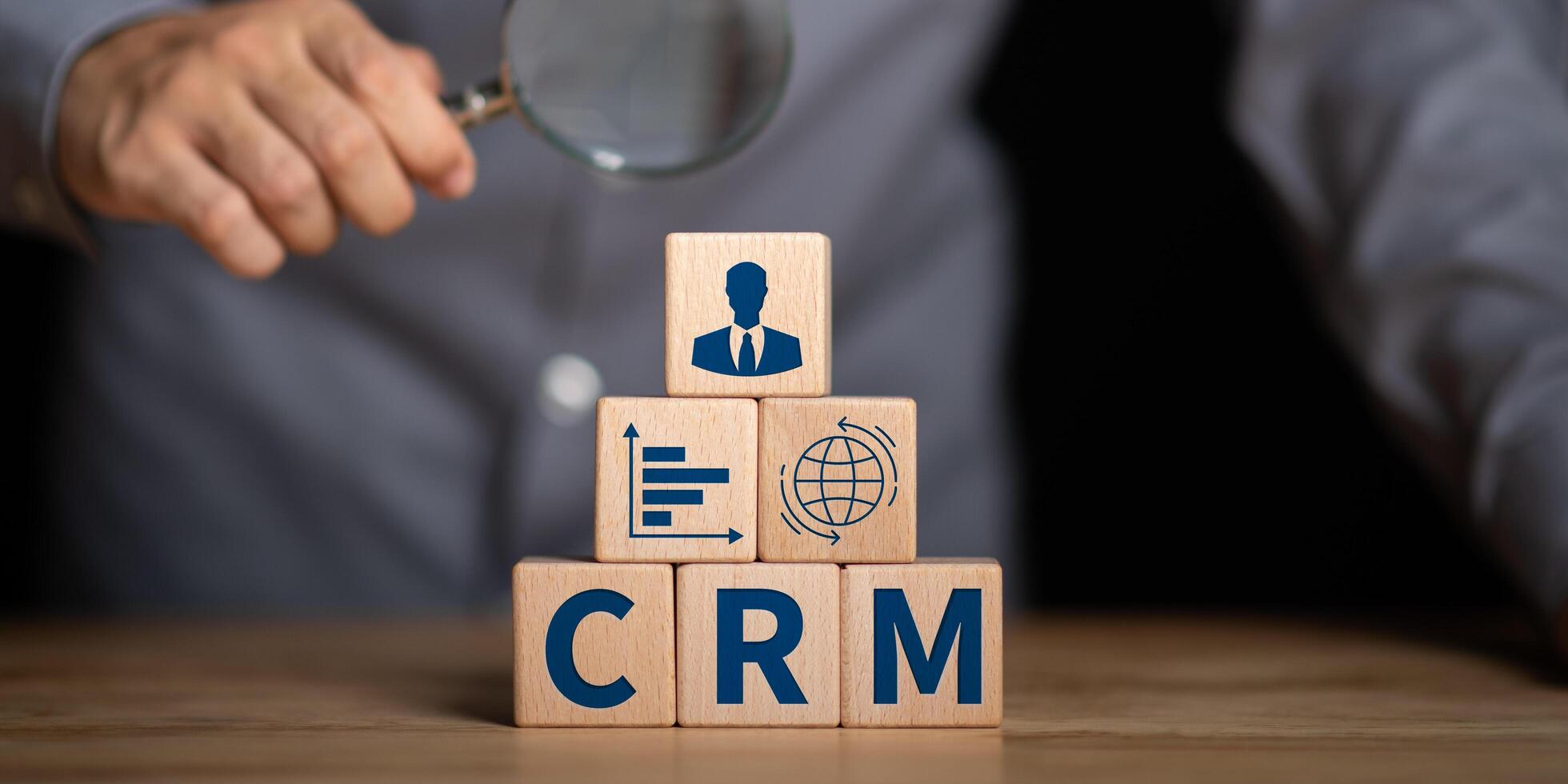 CRM concept with wooden blocks showing business icons and magnifying glass, representing customer relationship management, marketing strategy, and data analysis for business success. photo