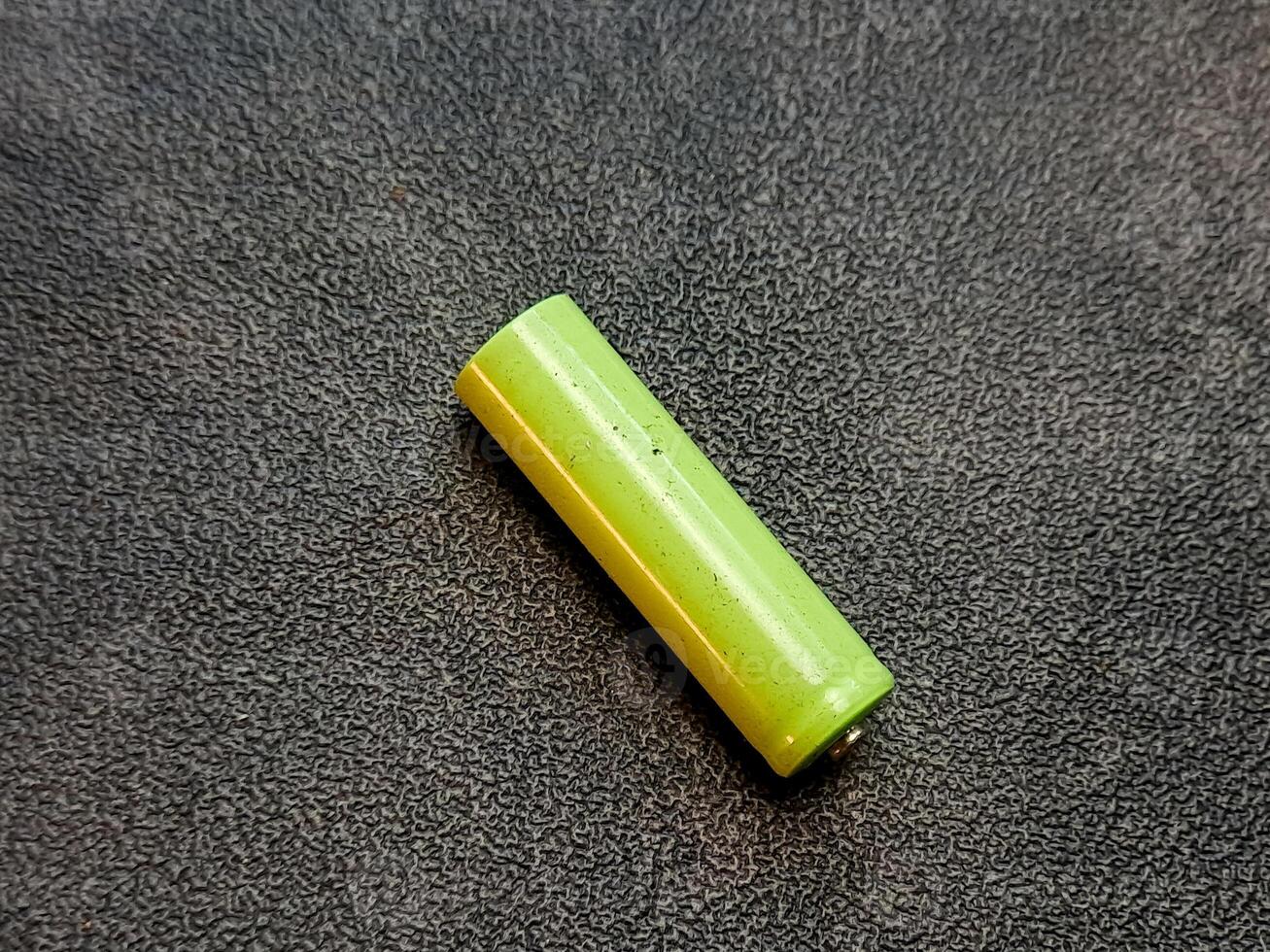 A cylindrical yellow-green object rests on a textured gray surface, casting a soft, diffused light. photo