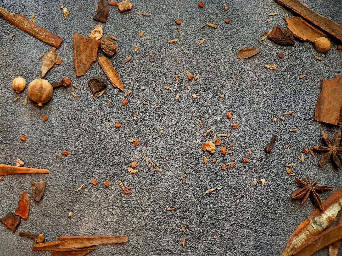 Scattered aromatic spices and herbs create a visually appealing culinary backdrop texture. photo
