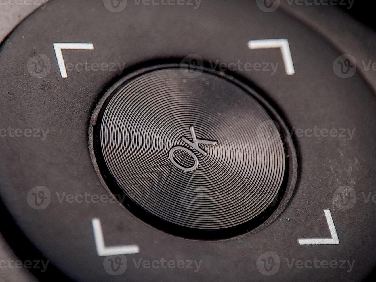 Macro image reveals textured navigation button with direction symbols and concentric circles. photo