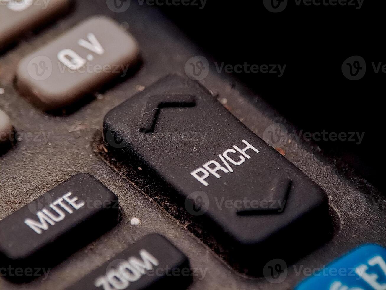 A remote control with channel and function buttons show signs of age and use on the surface. photo
