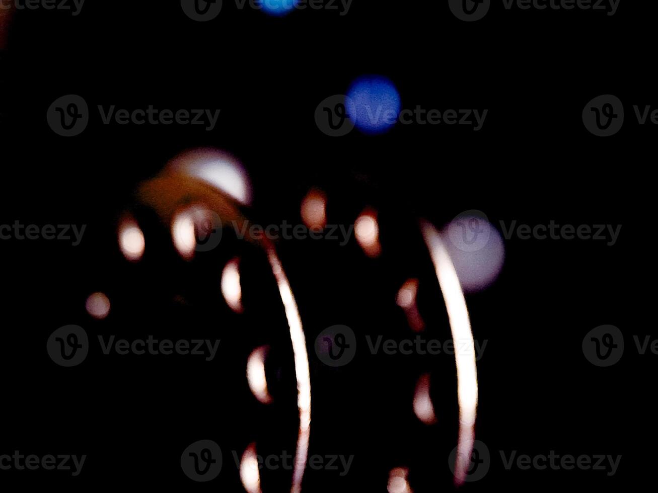 Abstract dark composition with glowing crescent shapes against a hazy, gradient-lit backdrop. photo