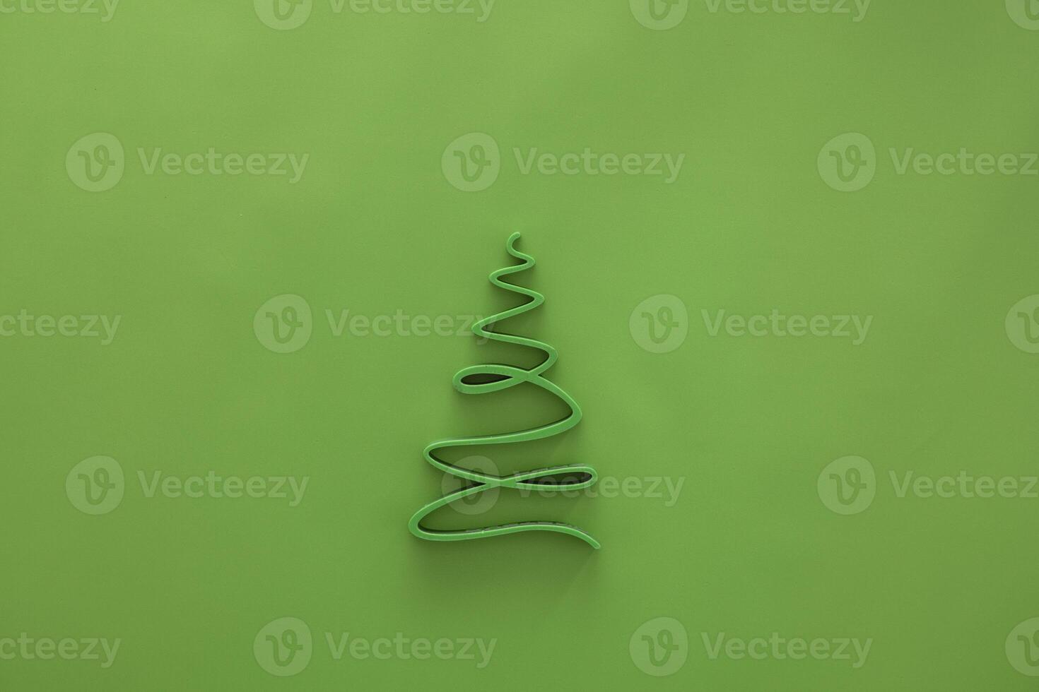 A simple green Christmas tree outline made of wire on a bright green background. The design is minimalistic and festive, suitable for holiday themes. photo