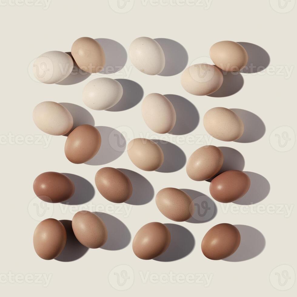 Easter eggs square pattern with gradient colored eggshell, hard Shadow at sunlight, beige background. Chicken eggs layout, top view, minimal flat lay, holiday food still life photo, trend photo