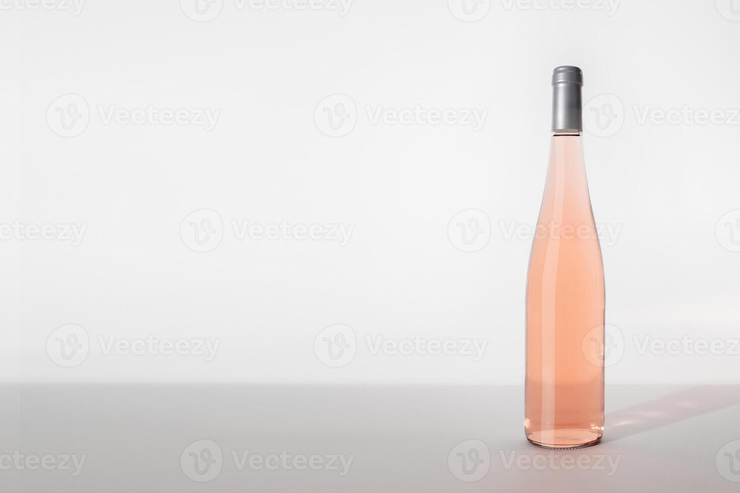 Rose wine bottle on table on light white background, side view, copyspace. Mockup product alcoholic drink in sunlight. One bottle Rose wine template, minimal still life, banner with empty space photo