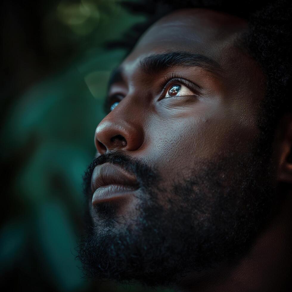 A Black Man Reflects Introspection, Surrounded by Lush, Natural Elements in Soft, Diffused Light photo