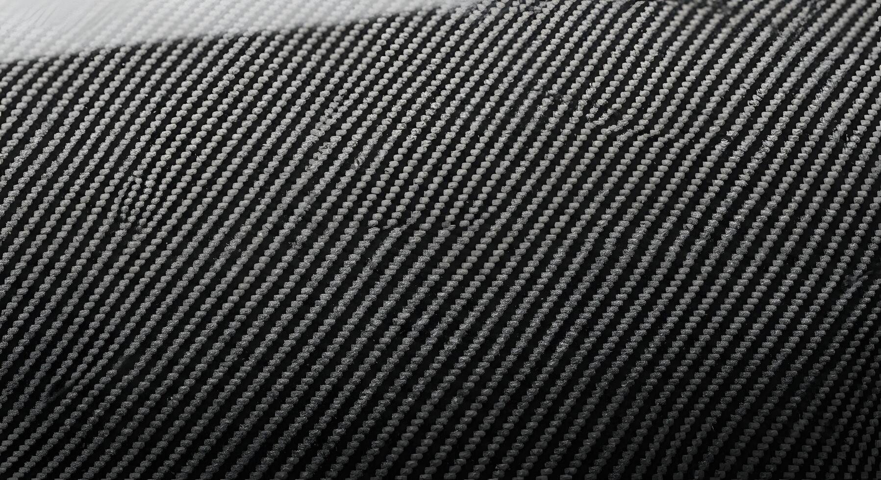 Detailed close-up of a dark woven synthetic fabric, showcasing its intricate diagonal pattern and robust texture, ideal for high-tech industrial design and modern material applications photo
