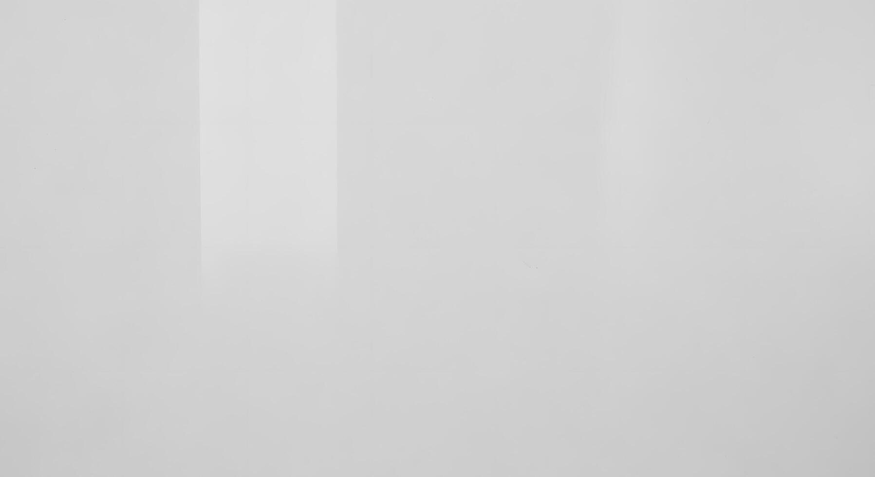 Minimalist white glossy surface background with subtle vertical reflections creating a smooth, clean, and modern abstract wall texture photo
