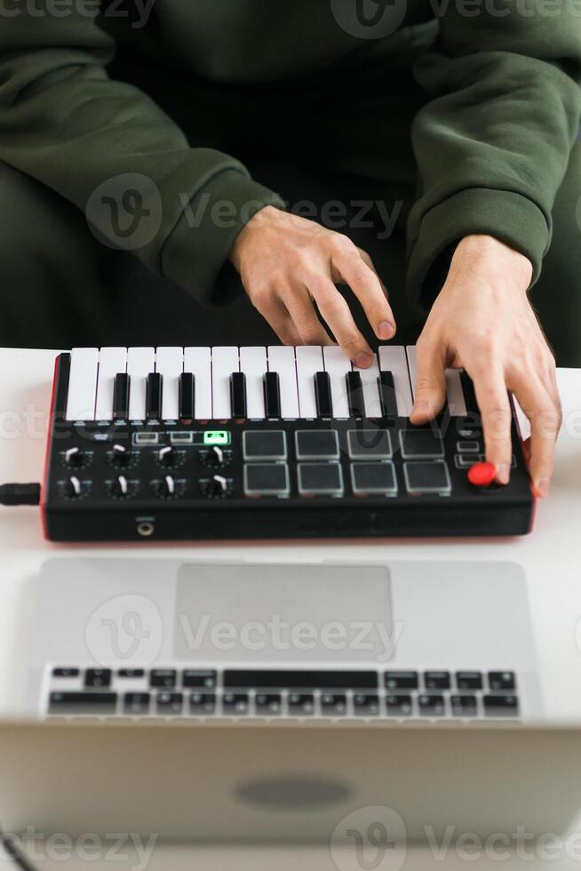 Top view of a music producer or arranger using laptop and midi keyboard and other audio equipment to create music at home studio. Beat making and arranging audio content and composing song photo