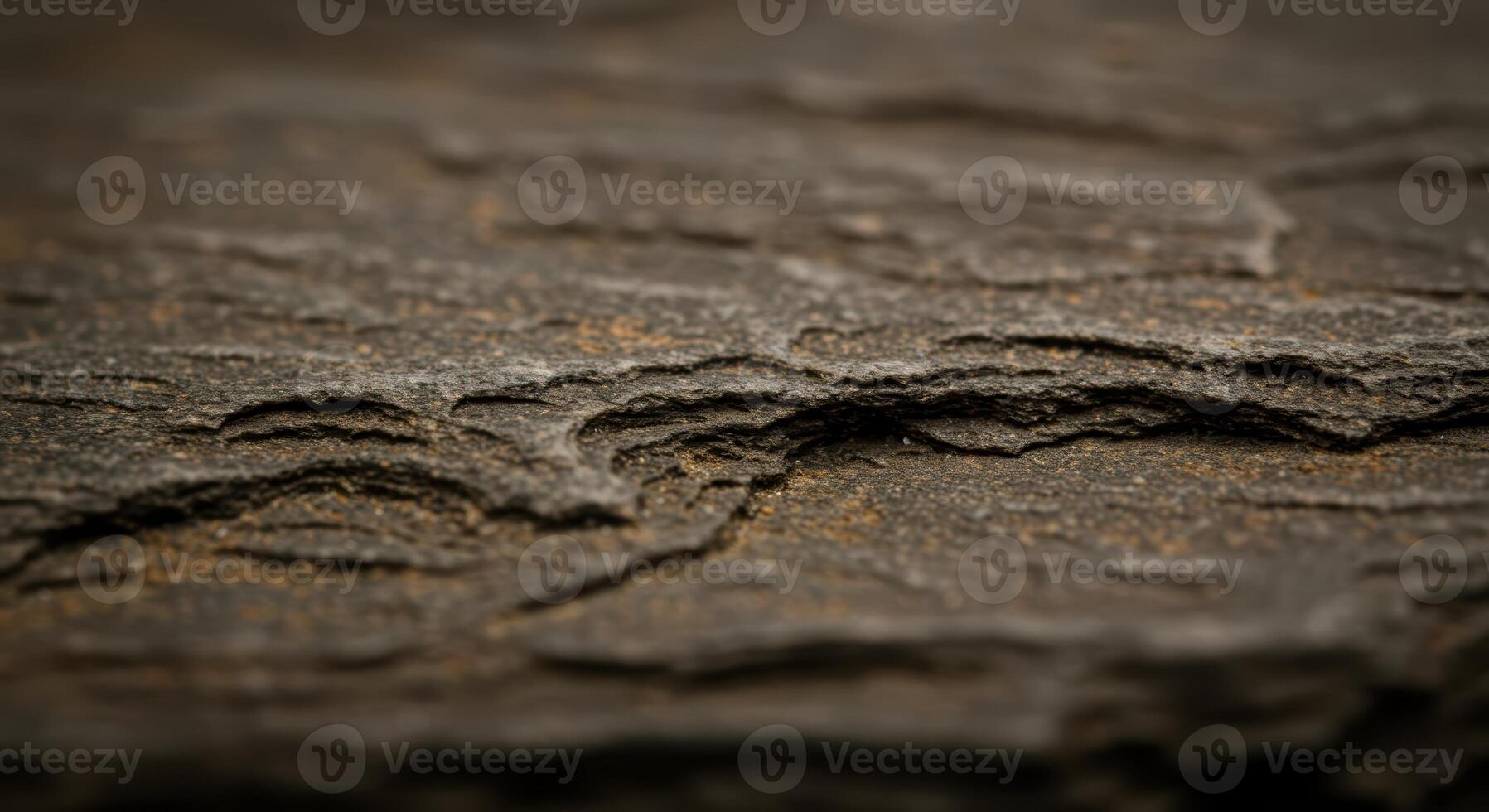 Close up of a dark grey slate rock surface showing its layered texture and rough edges creating a natural abstract pattern and background. photo