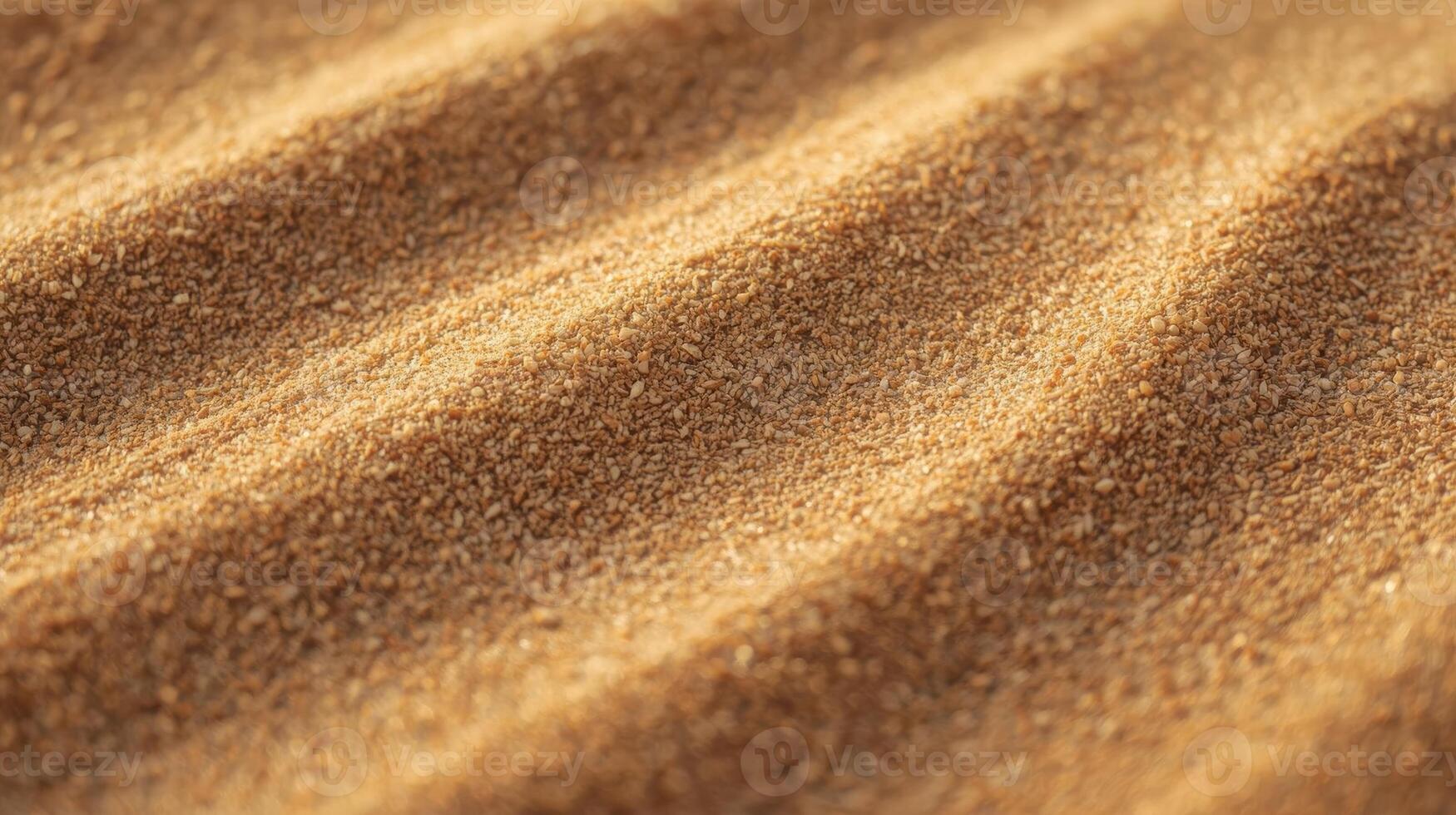Soft golden brown sand ripples diagonally across the frame creating a beautiful and textured desert background with warm lighting at sunrise. photo