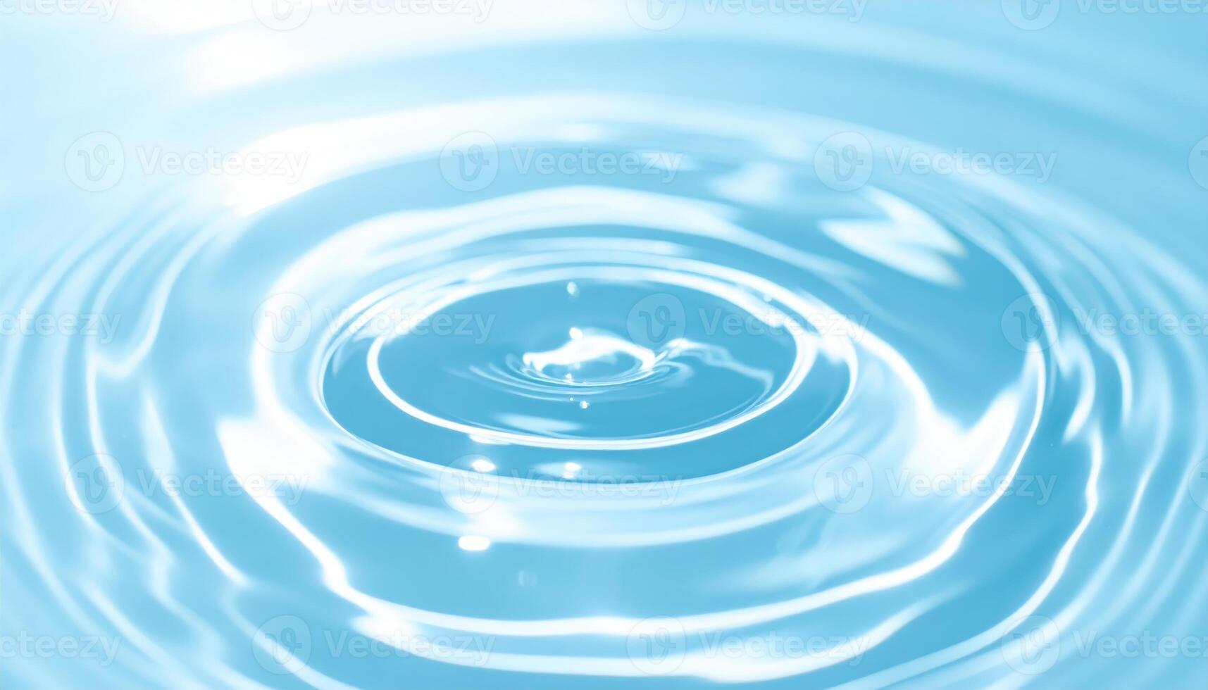 Circular ripples expanding outward on a tranquil body of light blue water creating a calming and serene natural pattern on the surface. photo