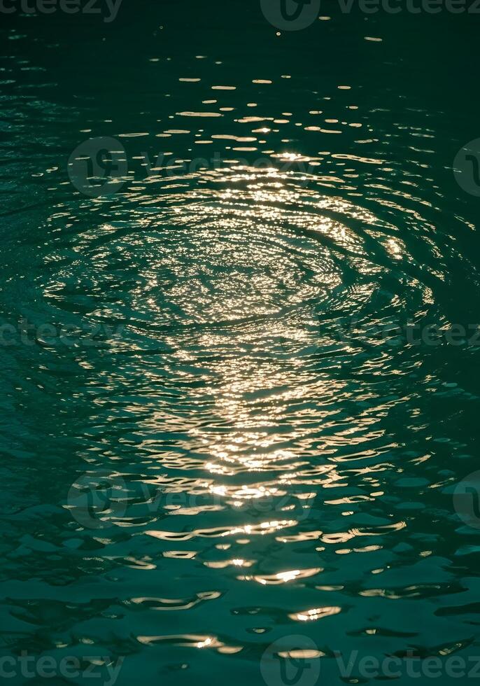 Abstract Water Surface with Light Reflections Creating Circular Patterns and an Emerald Green Hue Evoking Calmness and Serenity for Backgrounds and Textures photo