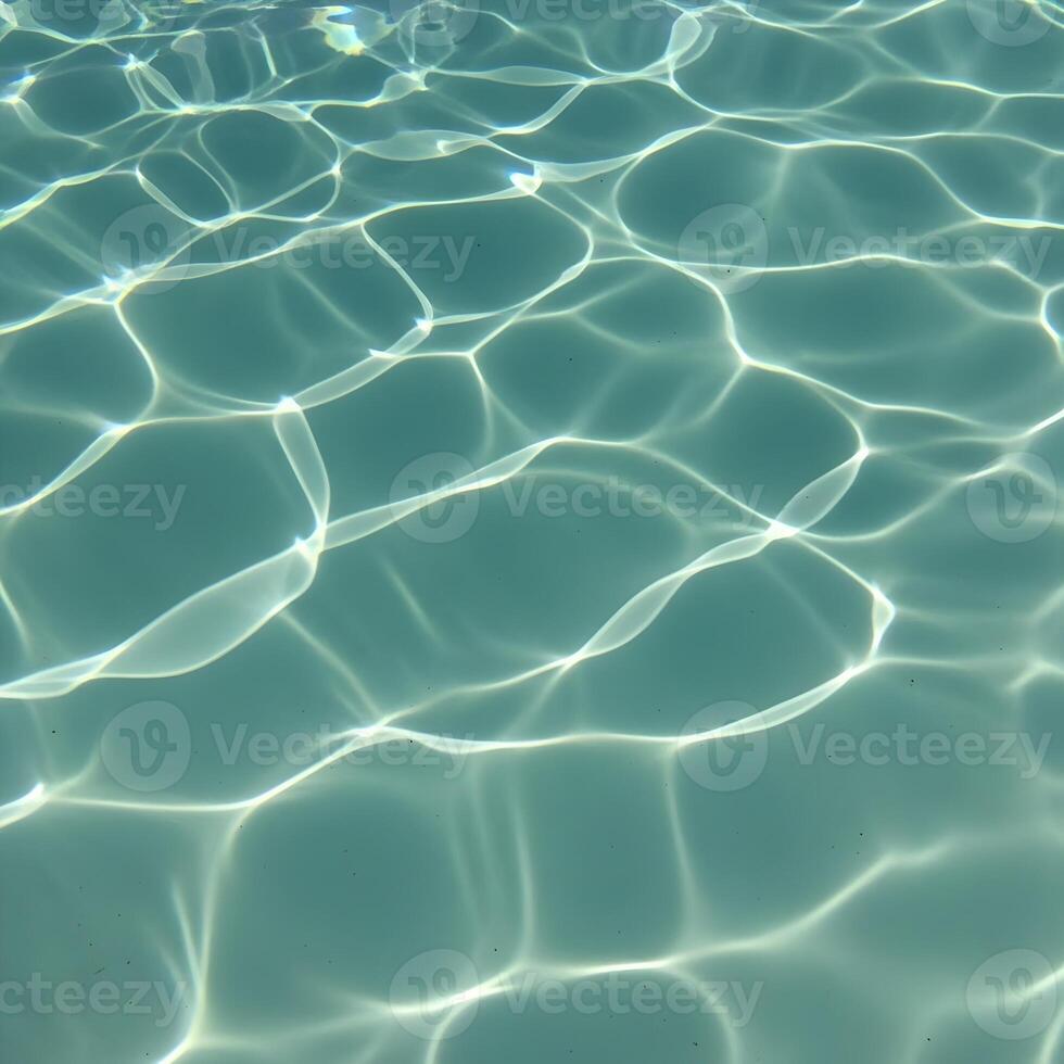 Sunlight reflecting and creating patterns on the surface of a turquoise swimming pool creating a sense of calmness and inviting relaxation for a summer getaway vacation photo
