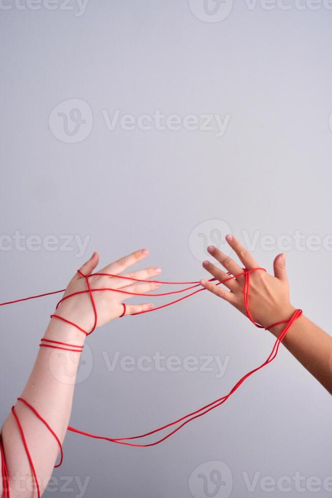 Connected hands creating red string relationship photo