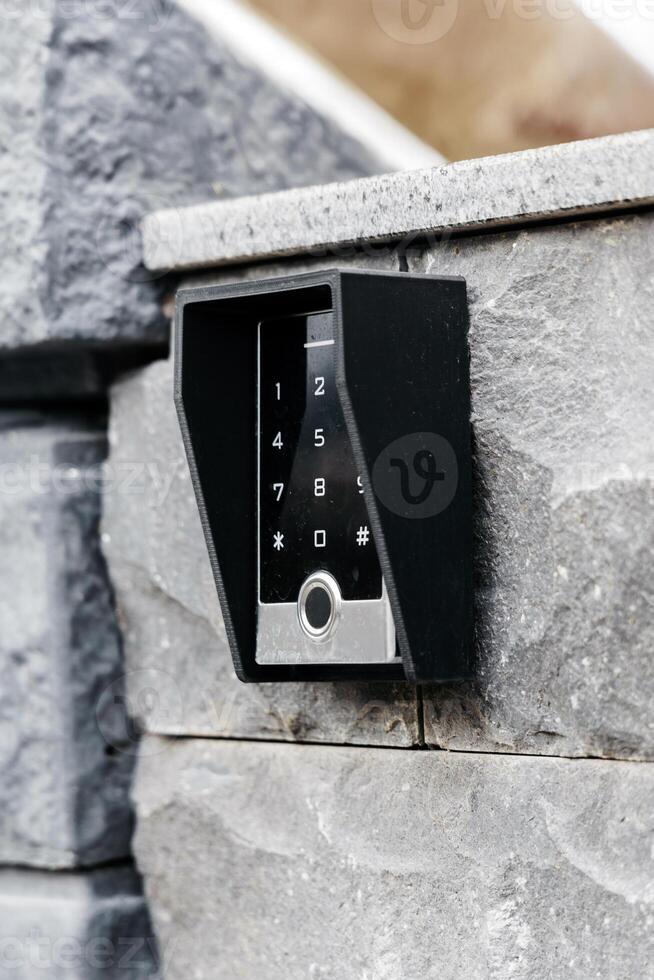 Modern electronic keypad entry system mounted on a stone wall, showcasing sleek design and functionality for secure access control in residential or commercial settings photo