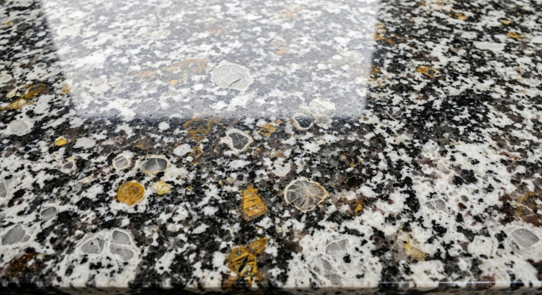 Close up abstract view of a textured surface with shimmering light reflecting on its varied speckled pattern photo