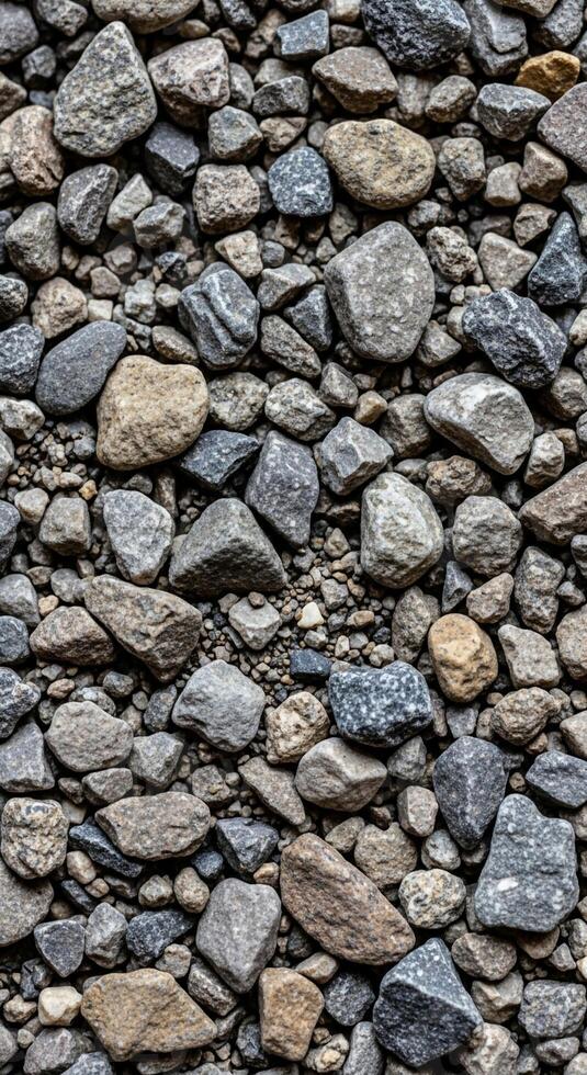 A close up view of a dense collection of varied sized and colored river stones creating a textured natural background pattern photo