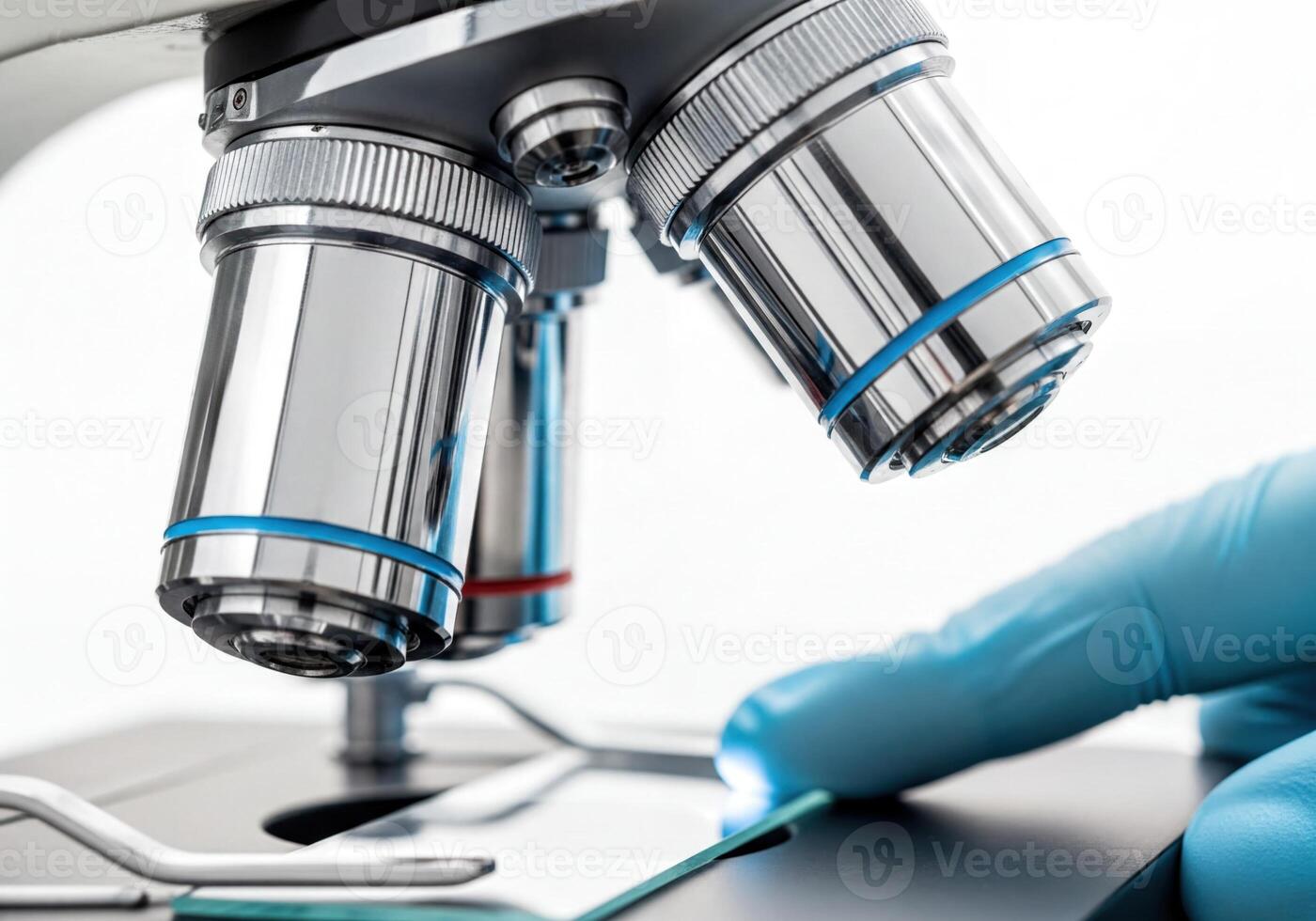 Close Up of Microscope Objective Lenses and Gloved Hand Placing Sample Slide in Laboratory photo