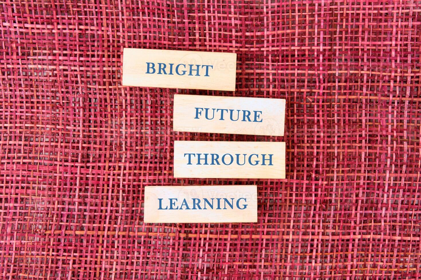 Four wooden blocks arranged on a textured background convey an inspiring message about the importance of learning for a bright future, inviting curiosity and hope photo
