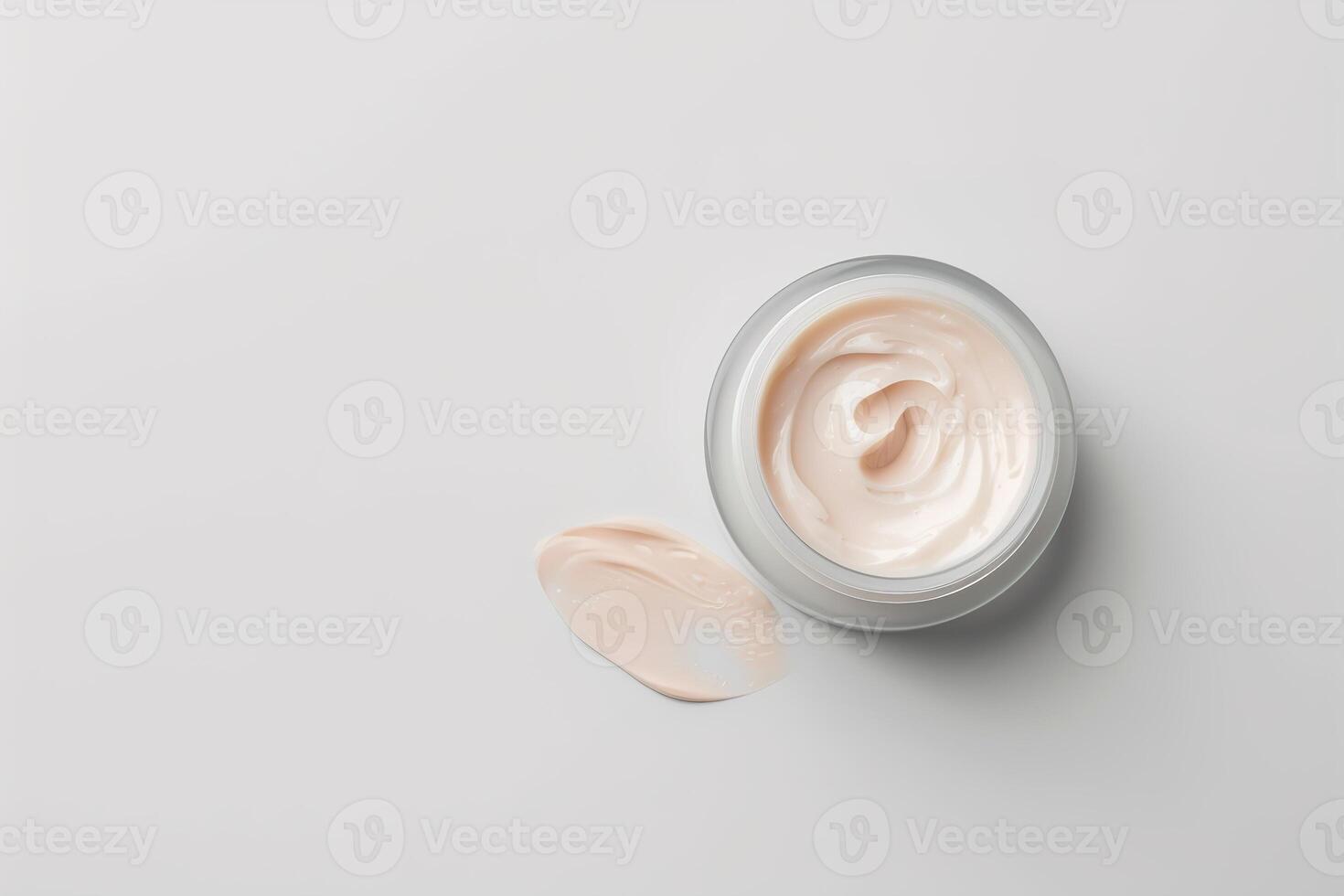 A clear skincare jar contains a creamy texture that is light in color. The jar is placed on a smooth, neutral backdrop, showcasing its luxurious appearance and soft consistency photo