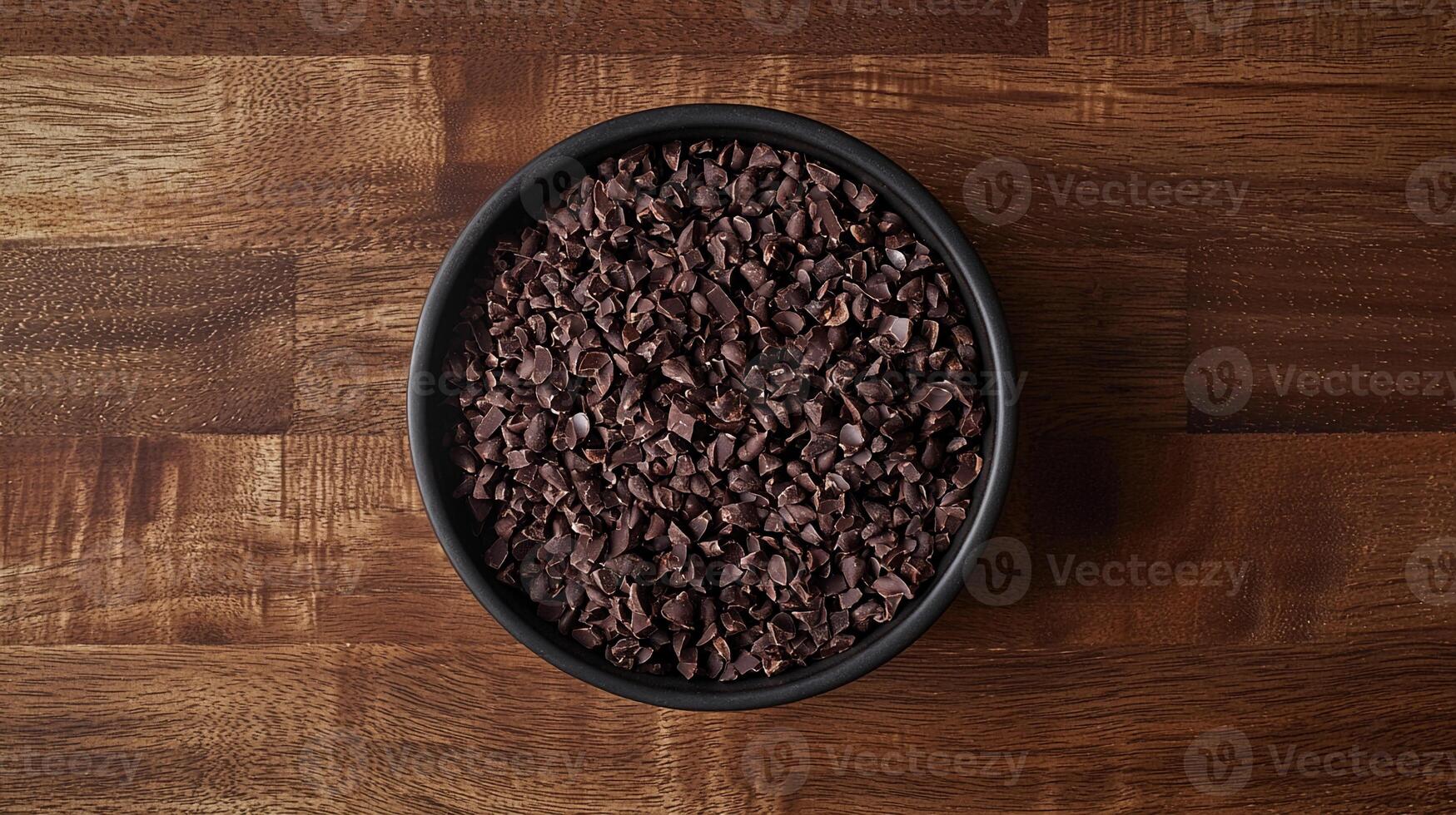 Nibs placed in a black bowl on a wooden surface for a minimal flatlay presentation photo