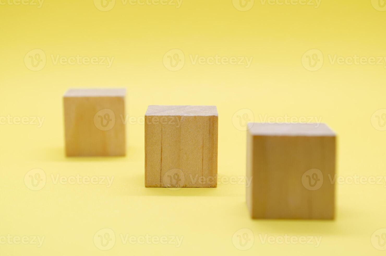Close up view of isolated wooden cube with customizable space for text or ideas on yellow background photo