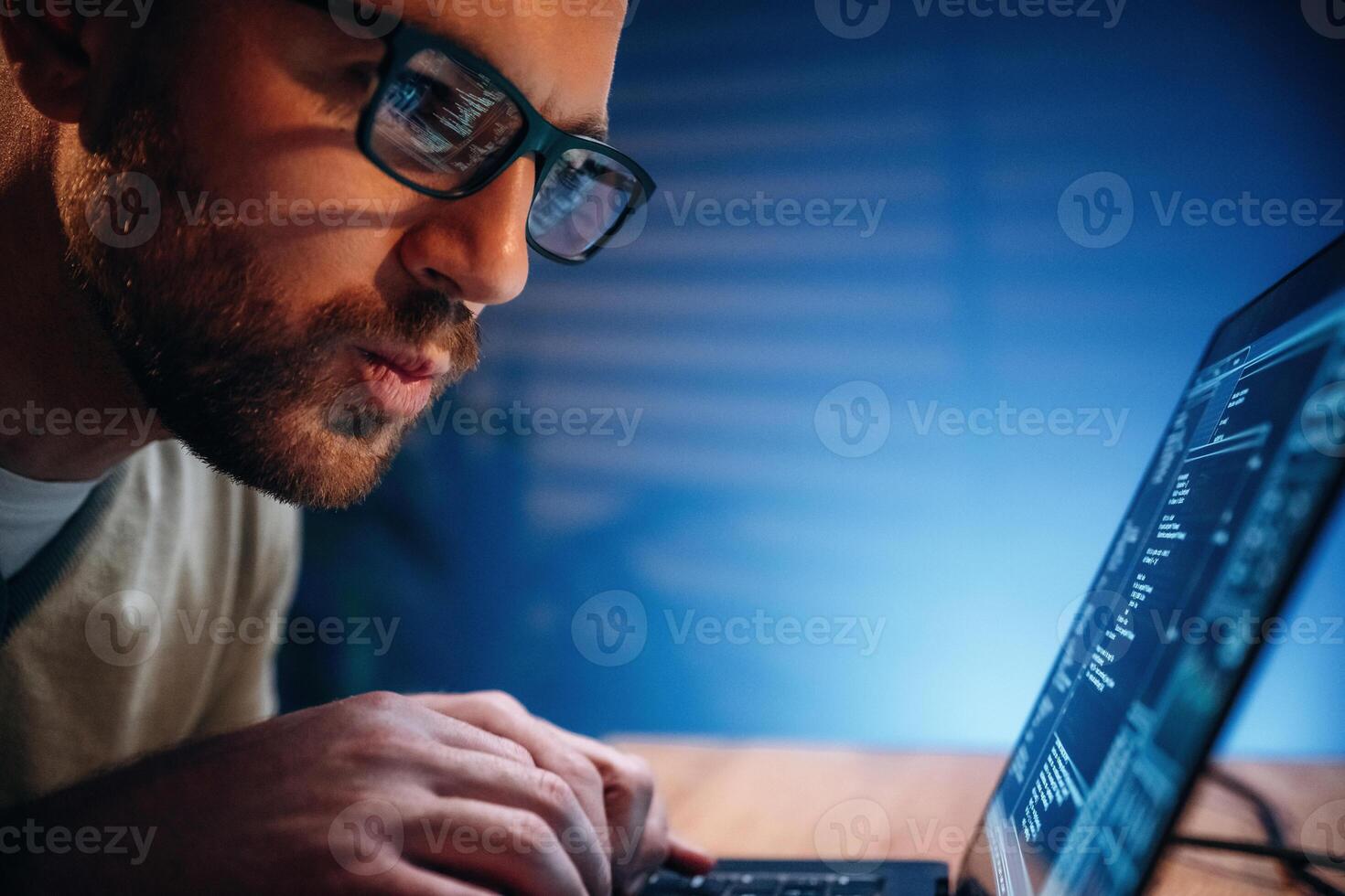 Person coding on a laptop at night photo