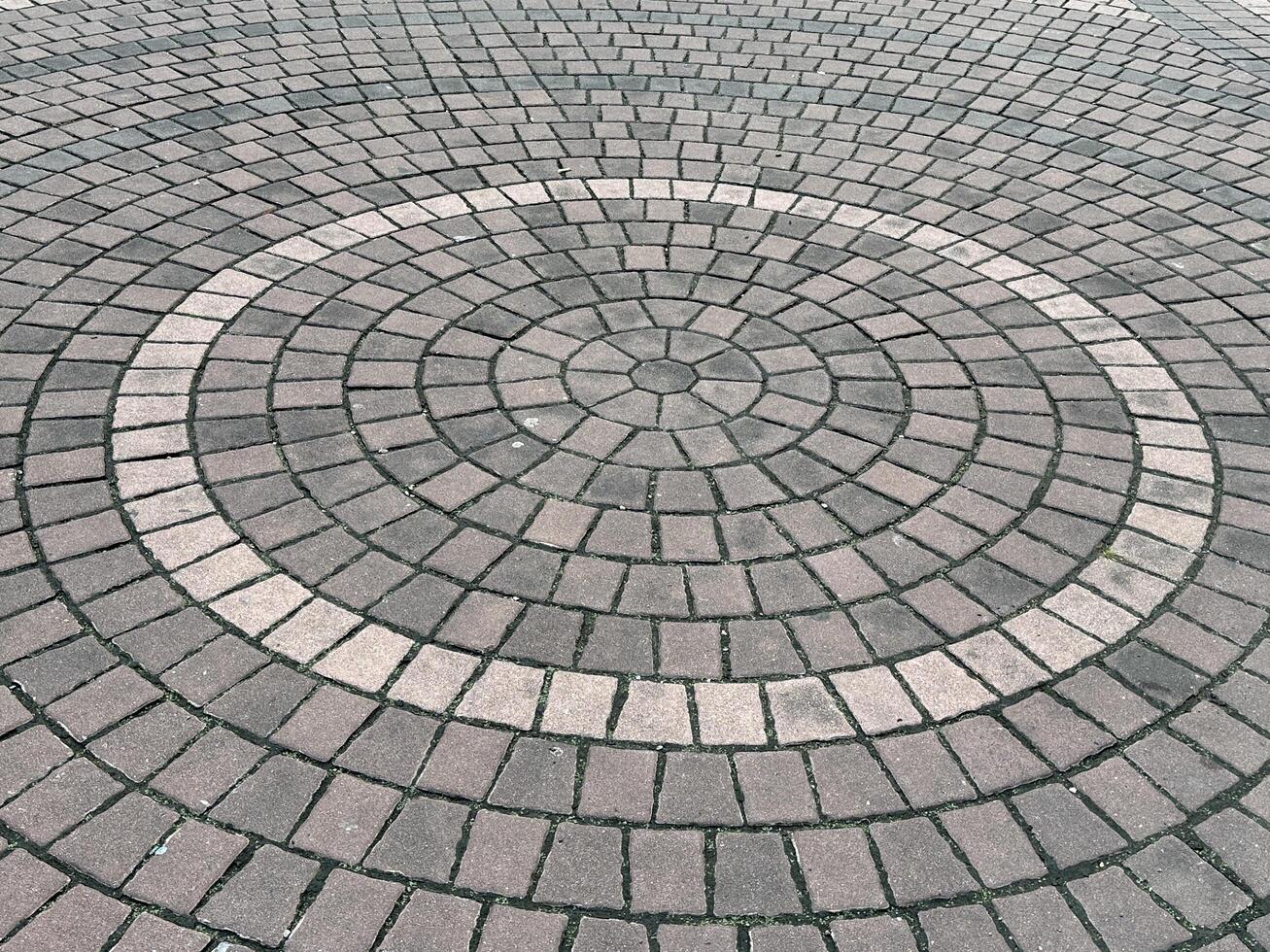 Circular Pattern of Paving Stones in a Symmetrical Design on a Sidewalk with Earthy Tones Perfect for Urban and Architectural Themes photo