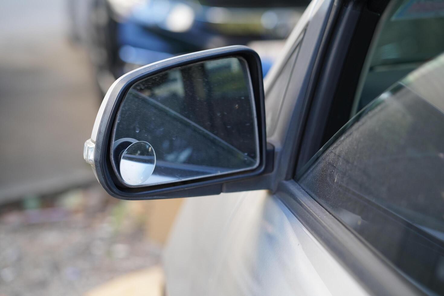 Close-up of a Car Side Mirror Reflecting Background Objects in Soft Focus, Showcasing Modern Vehicle Design and Clear Glass Surface photo