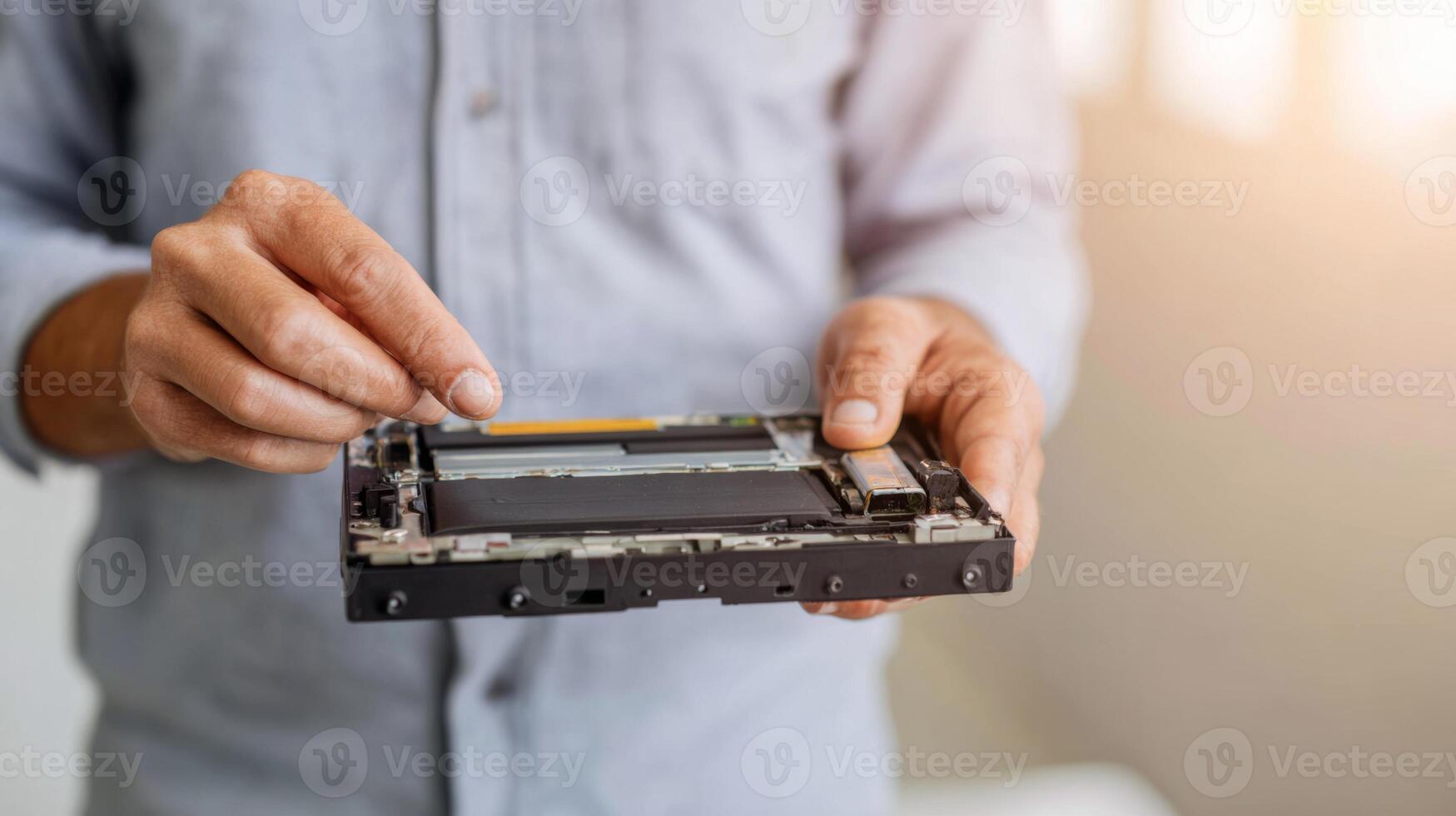 A male technician handling a disassembled hardware component with focus and precision, showcasing technical skill and attention to detail. photo