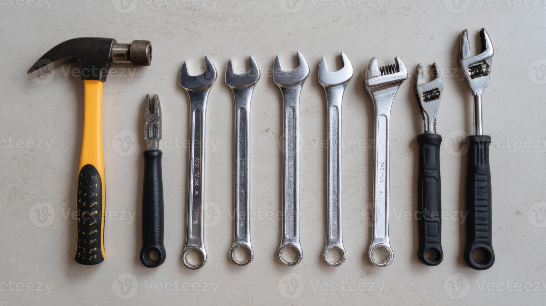 A collection of essential hand tools arranged neatly, including a hammer, pliers, and various wrenches. photo