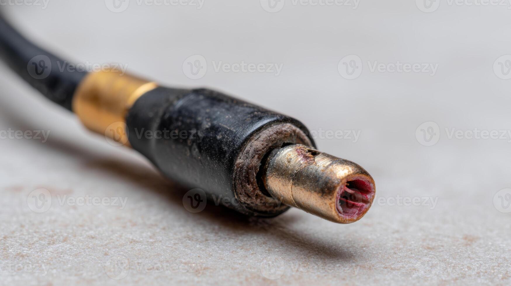 Close-up of a worn-out audio connector, showcasing intricate details and textures in a muted color palette. photo