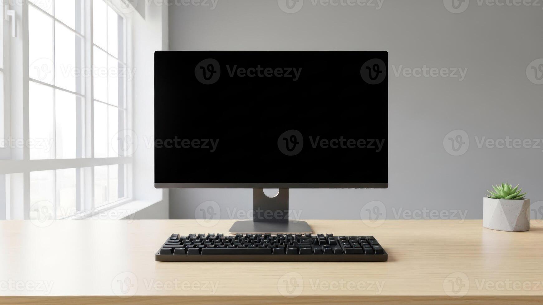 A computer monitor on a desk with a keyboard and mouse photo