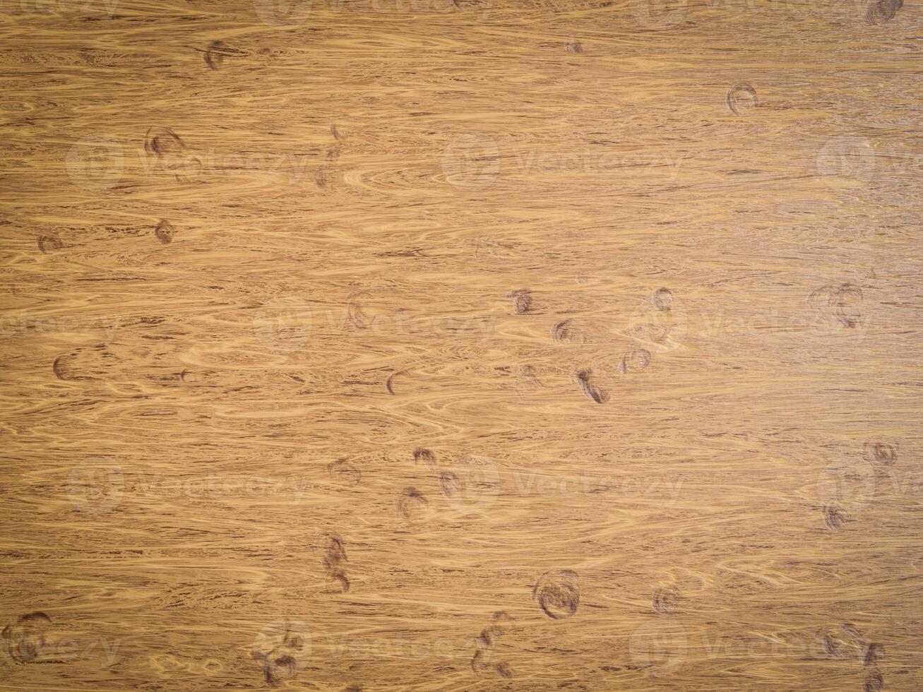 Light honey-colored wood with circular marks and flowing grain pattern visible across the surface. photo
