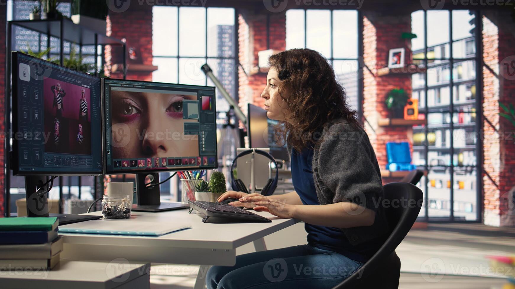 Woman expert developer works with photo editing software in the creative workspace, digital media. Using dual monitors to ensure productivity and innovation in the graphic design world. Camera A.