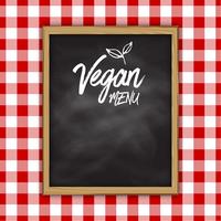 Pizarra de menú vegano sobre un fondo de tela a cuadros vector