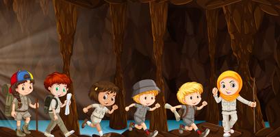 Niños explorando la cueva vector