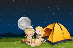 Niños acampando en la noche vector