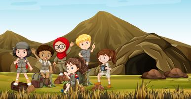 Kids in safari costume camping out by the cave vector